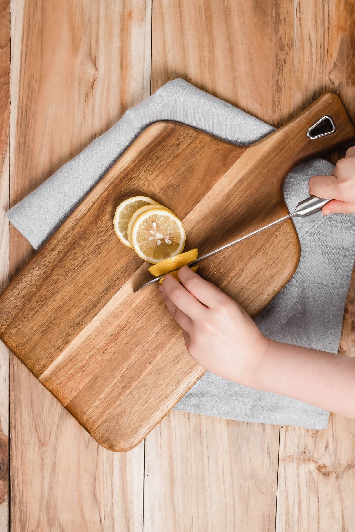 Gray pure linen tea towel beneath chopping board to prevent slippering