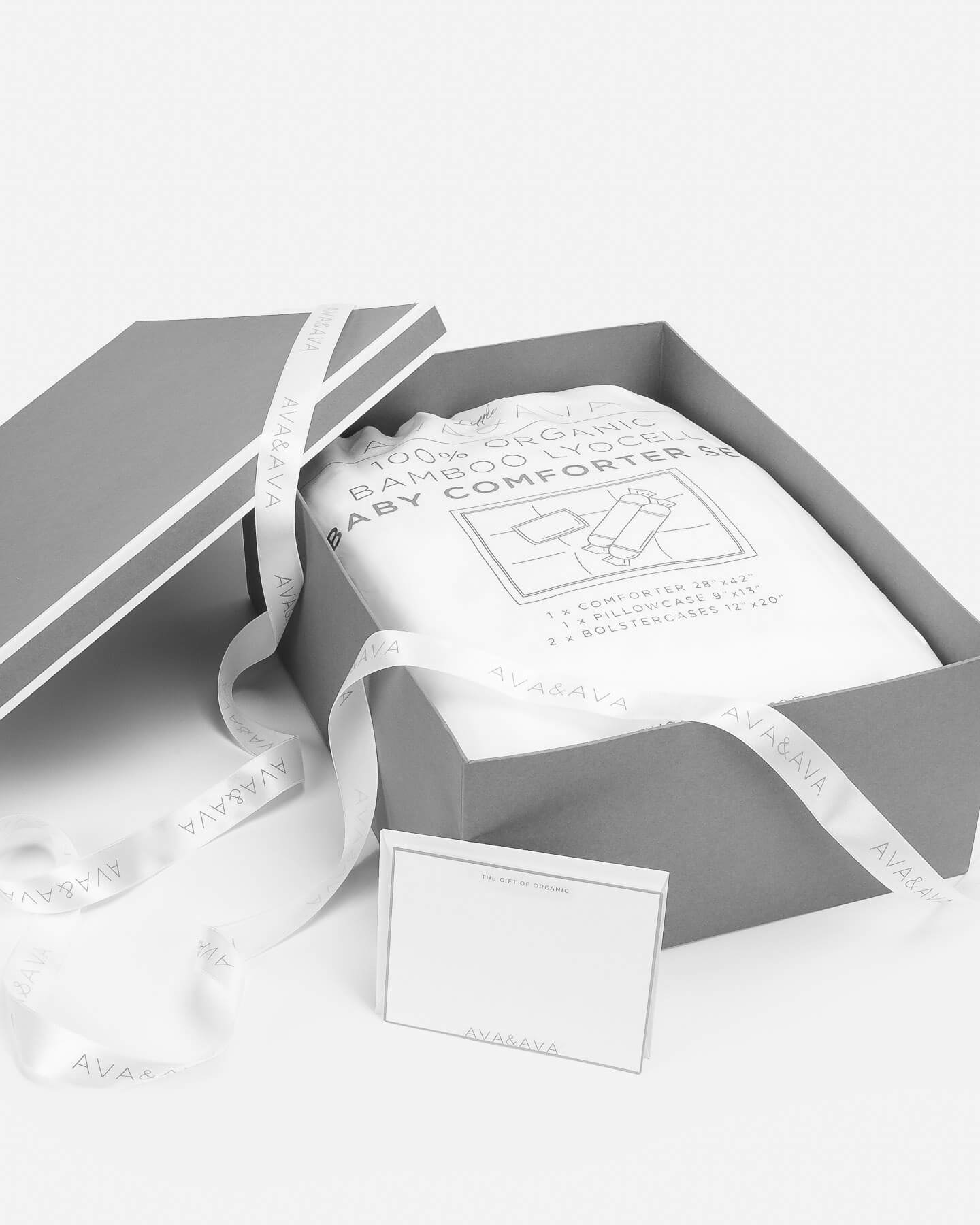 medium gray gift box with white piping, white satin ribbon and card, organic bamboo lyocell baby comforter set in white inside. gift for baby shower / newborn / new mothers