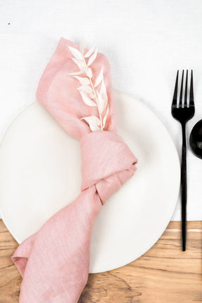 ava and ava pink pure linen table napkin on white plate, with black cutlery