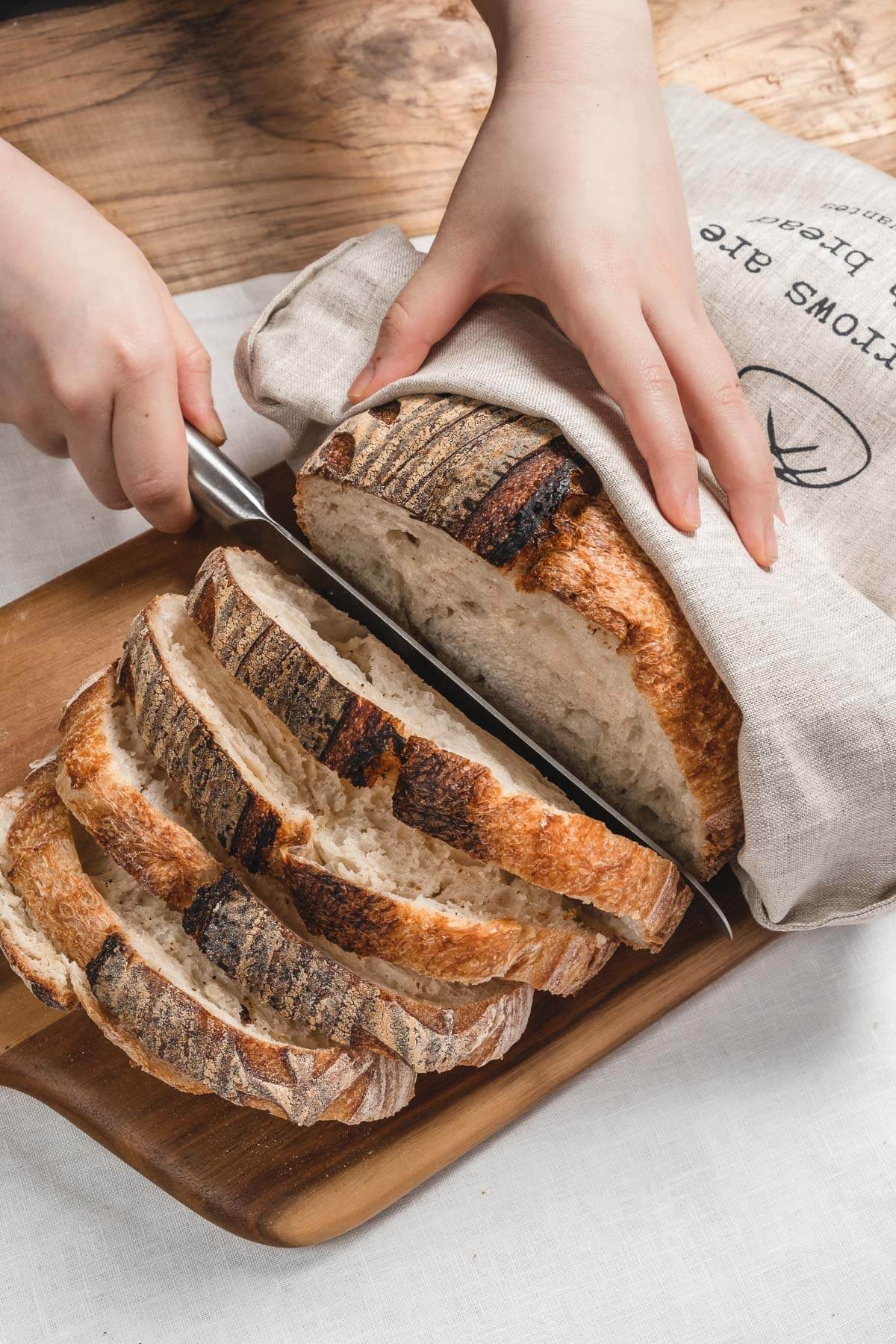 ava and ava ph Sliced sourdough loaf inside natural colored pure linen bread bag with black print - All sorrows are less with bread. - Miguel de Cervantes