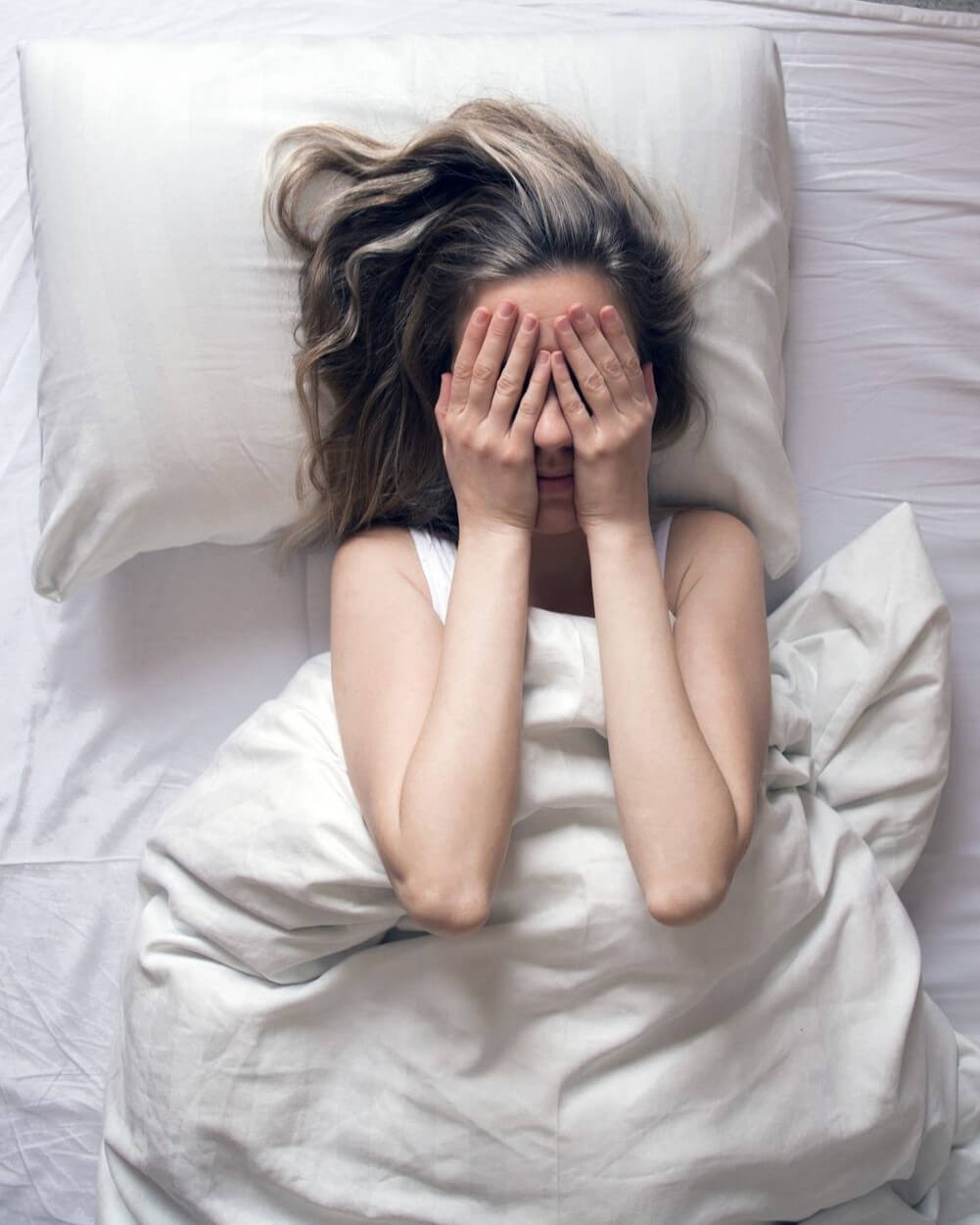 sleeping woman covering face stressed