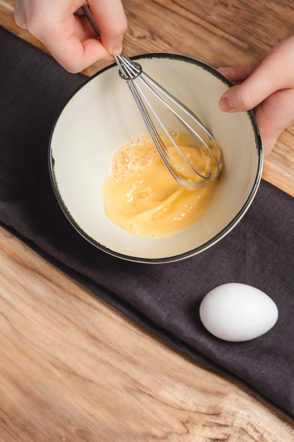 Charcoal pure linen tea towel underneath bowl whisking eggs to prevent slipping