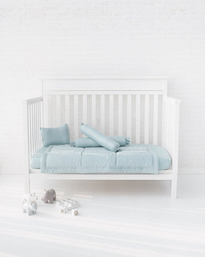 White crib with powder blue organic bamboo lyocell baby bedding (baby comforter set - 1 pillowcase, 2 bolstercases, 1 comforter; baby pillow set - 1 headshaping pillow, 2 bolsters; crib fitted sheet)