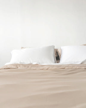 ava and ava ph organic bamboo lyocell duvet cover sheet set pillowcases in sand beige with white piping decorated with pampas summer vibes. soft and cooling bedding sheets.ava and ava ph organic bamboo lyocell duvet cover sheet set pillowcases in sand beige with white piping with white pillowcases. soft and cooling bedding sheets.