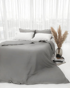 organic bamboo lyocell duvet cover and sheet set (fitted sheet and pillowcases) in urban oasis (gray with white piping) and silver lining (white with gray piping). ava and ava ph soft and cooling bedding sheets.