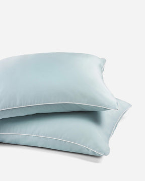 pair of sky blue organic bamboo lyocell pillowcases with white piping. ava and ava ph vegan silk, soft, cool, smooth, breathable pillowcases.