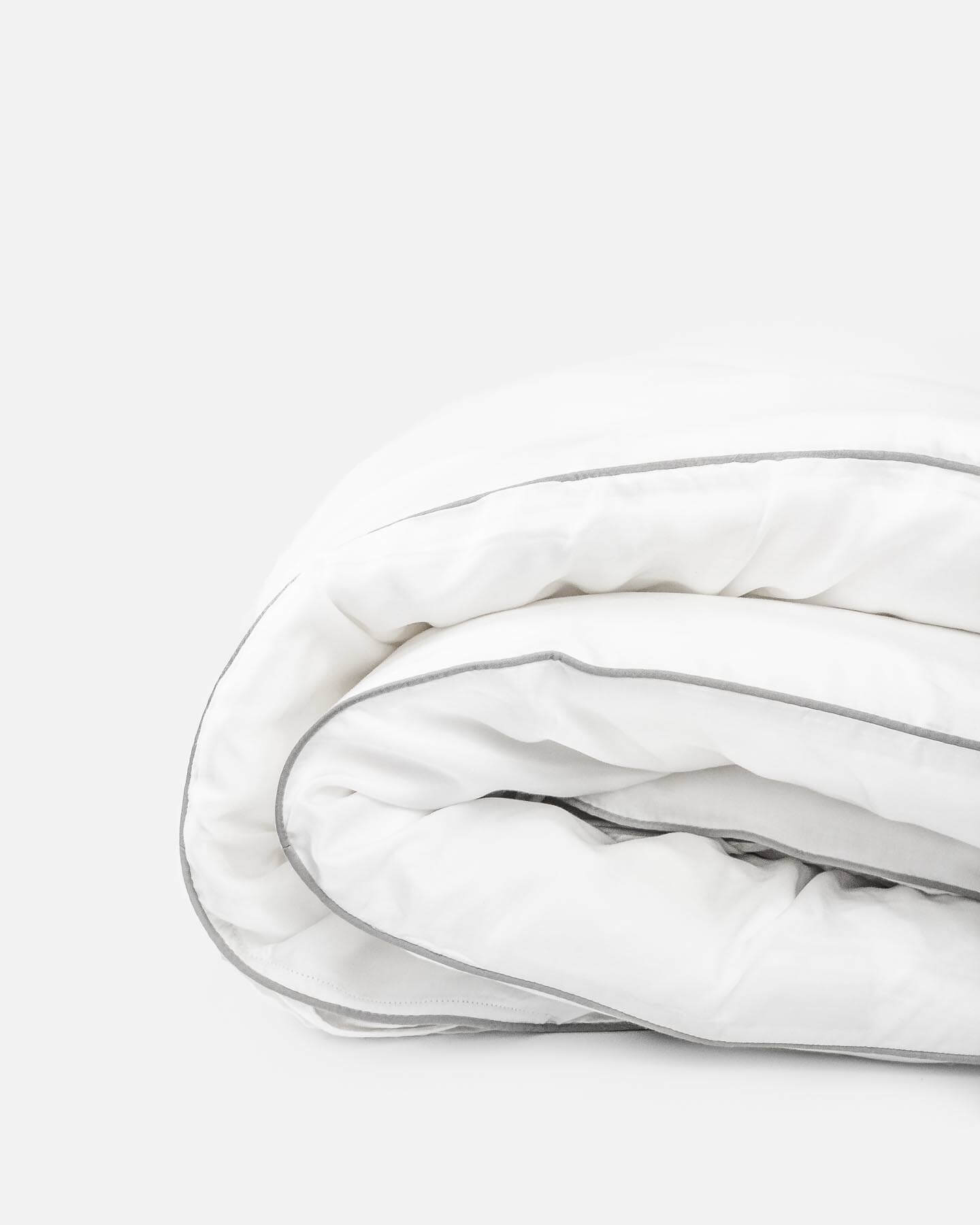 organic bamboo lyocell duvet cover rolled up side view in silver lining (white with gray piping). ava and ava ph soft and cooling bedding sheets.
