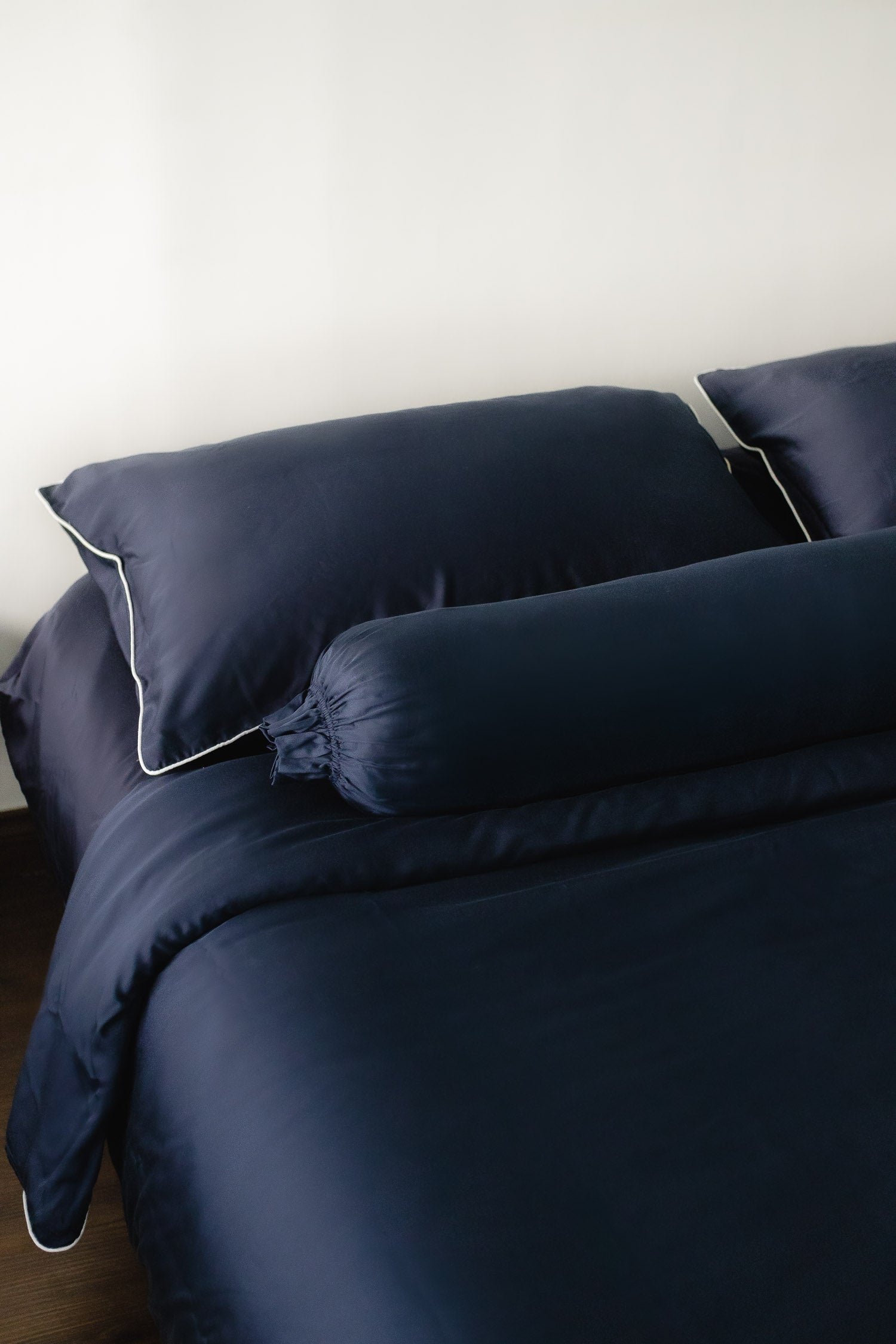 ava and ava ph organic bamboo lyocell bolster case / hotdog pillow / long pillow / po-tsim pillowcase in navy blue with navy sheets, pillowcases and duvet cover (white piping)