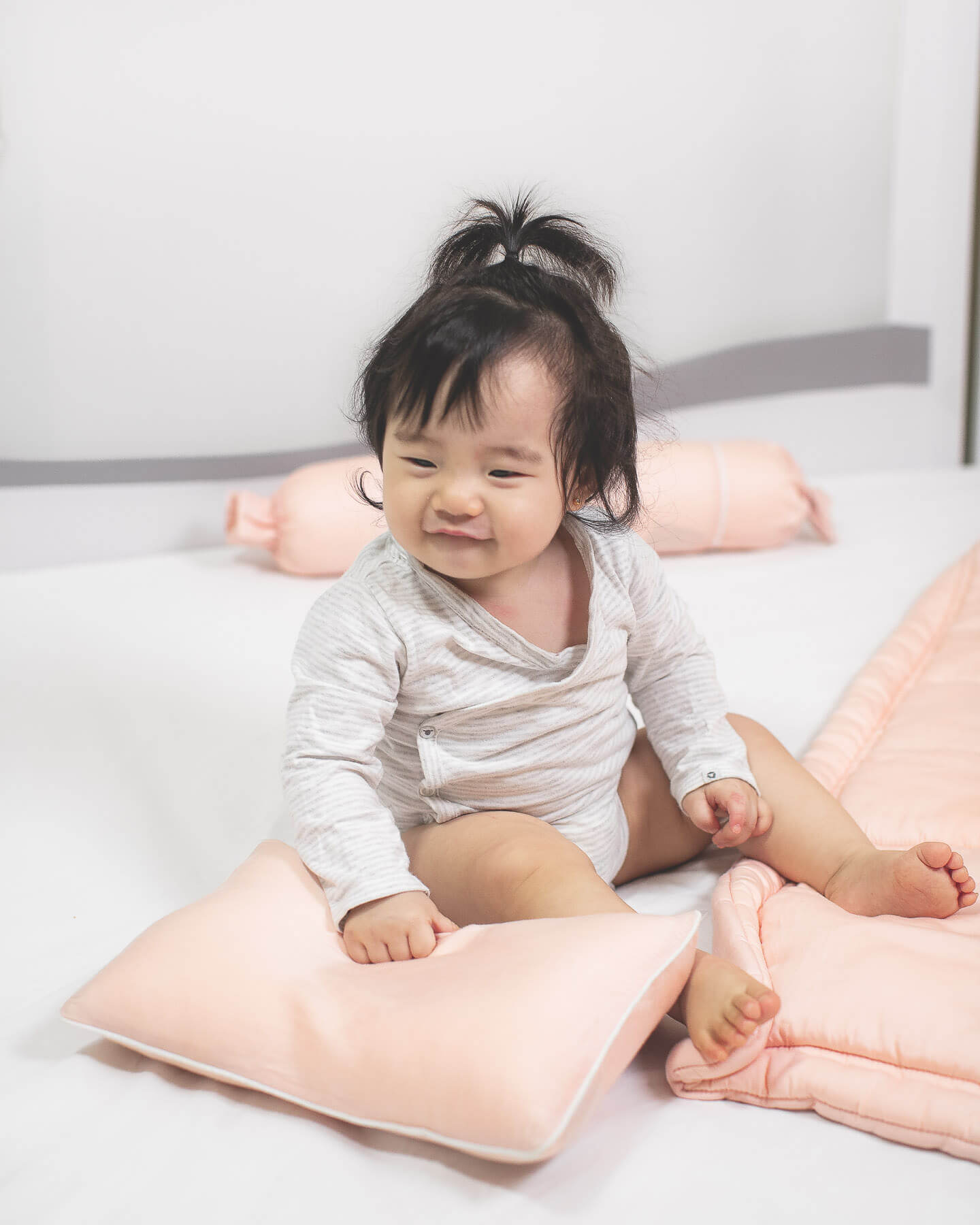 baby holding organic bamboo lyocell baby pillowcase set - pillowcase, 2 bolstercases in daydream blush (pink with white piping)