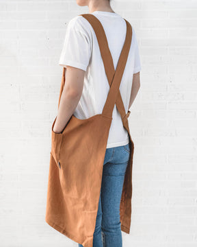 ava and ava ph caramel color pure linen crossback apron on female adult, crossback straps, no ties