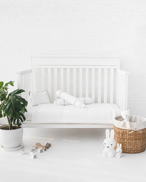 White crib with white organic bamboo lyocell baby bedding (baby comforter set - 1 pillowcase, 2 bolstercases, 1 comforter; baby pillow set - 1 headshaping pillow, 2 bolsters; crib fitted sheet)